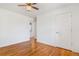Bedroom featuring hardwood floors, white walls, ceiling fan and a door to the laundry room at 11976 E Arizona Dr, Aurora, CO 80012