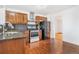 Traditional kitchen with wood cabinets, stainless steel appliances and hardwood floors at 11976 E Arizona Dr, Aurora, CO 80012