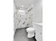 Modern bathroom featuring a toilet and shower with stylish black and white marble-look tiles at 12801 Randolph Pl, Denver, CO 80239