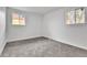 Bright bedroom with plush gray carpeting, fresh paint, and natural light from two windows at 12801 Randolph Pl, Denver, CO 80239