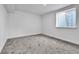 Bright bedroom with plush gray carpeting, fresh paint, and natural light from two windows at 12801 Randolph Pl, Denver, CO 80239