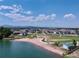 Scenic lake view with a sandy beach, a walking path, and residential community in the distance at 2078 S Teller Ct, Lakewood, CO 80227