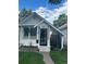 Charming white cottage with porch, landscaping, and black fence at 4418 Utica St, Denver, CO 80212