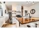 Modern kitchen with white cabinets, butcher block island, and exposed brick at 4418 Utica St, Denver, CO 80212