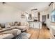 Open living space with L-shaped sofa, kitchen island, and hardwood floors at 4418 Utica St, Denver, CO 80212