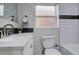 Updated bathroom features modern sink, vanity, tile backsplash, and tub at 4835 Grove St, Denver, CO 80221