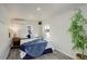 A cozy bedroom features white walls, a comfortable bed with a blue blanket, and an air conditioning unit at 4835 Grove St, Denver, CO 80221