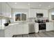 Modern kitchen featuring stainless steel appliances, white cabinetry, and sleek countertops at 4835 Grove St, Denver, CO 80221