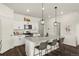 Bright kitchen offers white cabinets, pendant lighting, a granite-topped island with seating, and stainless appliances at 2326 Monte Vista St, Fort Lupton, CO 80621