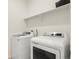 Clean laundry room featuring side-by-side washer and dryer with shelving for storage at 2326 Monte Vista St, Fort Lupton, CO 80621