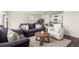 Open-concept living area features plush seating, a round coffee table, and modern decor, flowing into the kitchen at 2326 Monte Vista St, Fort Lupton, CO 80621
