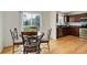Bright dining area with wood floors, stylish table and chairs, and a large window offering natural light at 25812 E Cedar Pl, Aurora, CO 80018