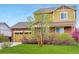 A beautiful two-story home with a stone facade, yellow siding, and a two-car garage at 25812 E Cedar Pl, Aurora, CO 80018