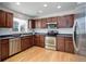 Well-equipped kitchen featuring stainless steel appliances, wood cabinetry, and ample counter space at 25812 E Cedar Pl, Aurora, CO 80018