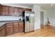 Functional kitchen area featuring stainless steel refrigerator, wood cabinetry, and hardwood floors at 25812 E Cedar Pl, Aurora, CO 80018