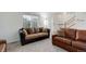 Spacious living area showcasing neutral carpeting, large windows, and a staircase leading to the upper level at 25812 E Cedar Pl, Aurora, CO 80018