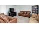 Cozy living room featuring comfortable leather furniture, plush carpeting, and built-in bookshelves at 25812 E Cedar Pl, Aurora, CO 80018