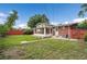 Grassy backyard featuring a brick home with a screened-in porch at 1330 Quari St, Aurora, CO 80011