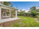 A spacious backyard features a screened-in porch, grassy lawn, and lush perimeter landscaping and wooden fence at 1330 Quari St, Aurora, CO 80011