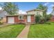 Charming brick home featuring a well-manicured lawn, welcoming entrance and neat garden bed at 1330 Quari St, Aurora, CO 80011