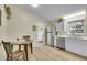 Modern kitchen featuring updated appliances, wood laminate flooring, and white cabinetry at 1330 Quari St, Aurora, CO 80011