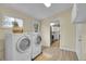Functional laundry room equipped with modern washer and dryer, bright windows, and ample space at 1330 Quari St, Aurora, CO 80011