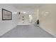 Open living room features soft carpet, built-in shelving and access to the adjacent kitchen at 1330 Quari St, Aurora, CO 80011