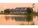 Stately building overlooking a serene pond, featuring classic architecture and multiple American flags at 16552 E 109Th Ave, Commerce City, CO 80022