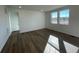 Open living room with wood-look floors and natural light from two large windows, creating a welcoming ambiance at 16552 E 109Th Ave, Commerce City, CO 80022