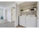 Bright laundry room featuring a stacked washer and dryer and convenient built-in shelving at 3550 S Harlan St # 182, Denver, CO 80235