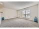 This large, naturally lit living room features neutral paint, plush carpet, and large windows at 3550 S Harlan St # 182, Denver, CO 80235