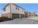 Exterior view of a two-story townhome featuring a two-car garage and stone accents at 22272 E 7Th Pl, Aurora, CO 80018