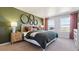 Bright main bedroom with green accent wall, cozy bedding, and ample natural light from large windows at 22272 E 7Th Pl, Aurora, CO 80018