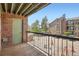 Balcony featuring black railings, brick, green door, and complex views with ample parking at 4899 S Dudley St # 15G, Littleton, CO 80123