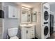 Bathroom featuring white vanity, mirror, toilet, and washer/dryer combo at 4899 S Dudley St # 15G, Littleton, CO 80123