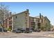 Apartment building exterior showcasing multi-level architecture with balconies and ample parking spaces at 4899 S Dudley St # 15G, Littleton, CO 80123