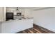 Bright kitchen with stainless steel appliances, black accents, white cabinetry, and wood-look flooring at 4899 S Dudley St # 15G, Littleton, CO 80123