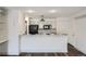 Bright kitchen with stainless steel appliances, black accents, white cabinetry, and wood-look flooring at 4899 S Dudley St # 15G, Littleton, CO 80123
