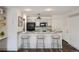 Kitchen featuring seating at a breakfast bar with black appliances and white cabinets at 4899 S Dudley St # 15G, Littleton, CO 80123