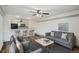 Open living area with a kitchen featuring a breakfast bar, seating, and modern gray furnishings at 4899 S Dudley St # 15G, Littleton, CO 80123