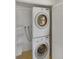 Convenient laundry room featuring stacked washer and dryer and storage shelves at 1584 S Salem Cir, Aurora, CO 80012