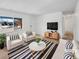 Bright living room with neutral walls, large window, and stylish black and white striped rug at 1584 S Salem Cir, Aurora, CO 80012