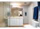 Bathroom featuring double sinks, walk-in shower, and neutral color palette at 1143 Auraria Pkwy # 203, Denver, CO 80204