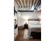 Comfortable bedroom with a plush bed, wooden beams, and a unique design that enhances the cozy and inviting atmosphere at 1143 Auraria Pkwy # 203, Denver, CO 80204