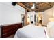 Bedroom with a dresser, exposed ceiling structure, and access to a walk-in closet and en suite bathroom at 1143 Auraria Pkwy # 203, Denver, CO 80204