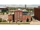 Exterior view of brick apartment building with well-maintained landscaping and a parking lot at 1143 Auraria Pkwy # 203, Denver, CO 80204