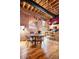 Dining area featuring hardwood floors, modern lighting, and exposed brick wall at 1143 Auraria Pkwy # 203, Denver, CO 80204
