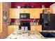 Modern kitchen with stainless steel appliances, granite countertops, and a stylish red accent wall, creating a chic space at 1143 Auraria Pkwy # 203, Denver, CO 80204
