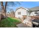 Landscaped backyard with grassy area, deck, and detached garage at 4820 Newton St, Denver, CO 80221