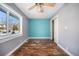 Bedroom with hardwood floors, light teal accent wall, and ceiling fan at 4820 Newton St, Denver, CO 80221